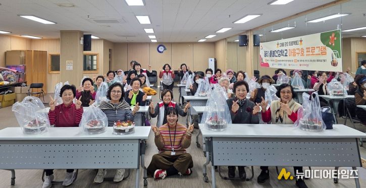 중리돌봄건강학교에서 열린 심리교육 및 크리스마스 테라리움 체험에 참여한 어르신들이 손가락 하트를 만들며 기념 촬영을 하고 있다.