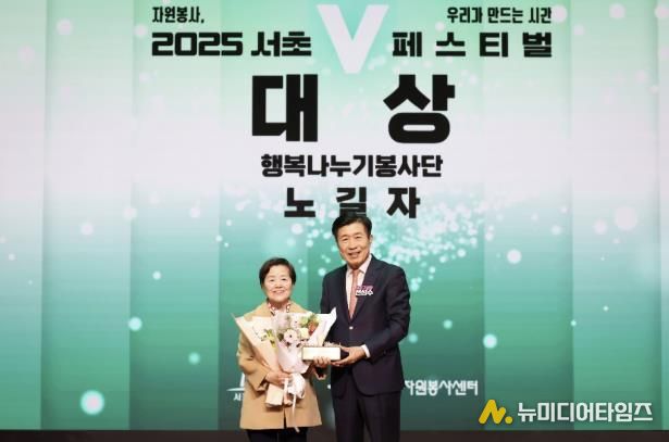 전성수 서초구청장(우측)이 ‘2025 서초V페스티벌’에서 자원봉사대상을 수상한 행복나누기봉사단 노길자 단장과 기념사진을 찍고 있다