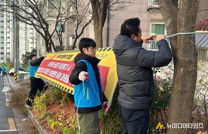서경대학교 학생들이 무단투기 금지 현수막을 달고 있다.