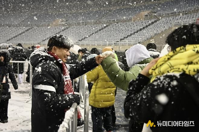 부천FC1995의 승강 PO 1차전이 폭설로 연기된 후 돌아가는 시민들과 조용익 부천시장이 주먹인사를 나누고 있다.