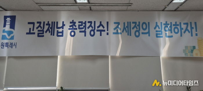 ‘고질체납 총력 징수! 조세정의 실현하자!’ 수원시 징수과 사무실에 걸려 있는 현수막.