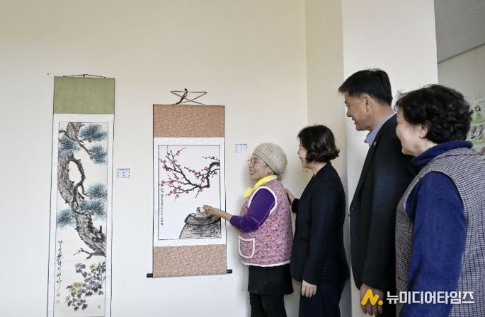 영인면 행정복지센터 층간 통로에 전시된 문인화반 작품을 주민들이 감상하고 있다.