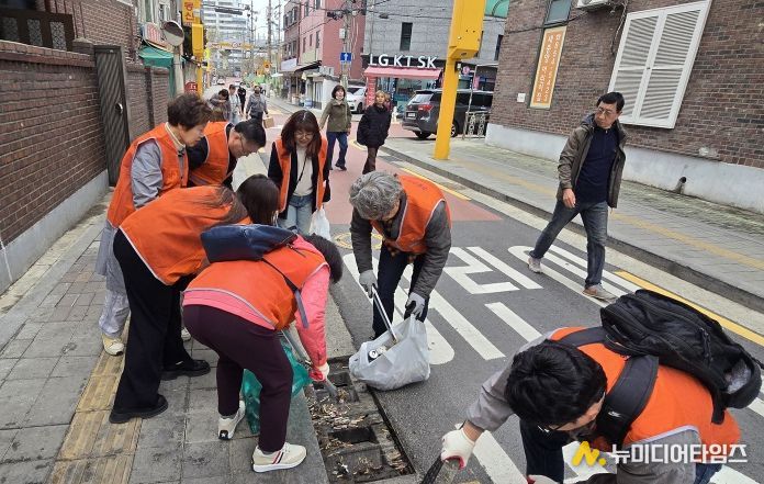 구로구소상공인연합회 회원들이 3월 31일 상권 일대에서 쓰레기 수거와 빗물받이 청소 등 환경정화 활동을 하고 있다.