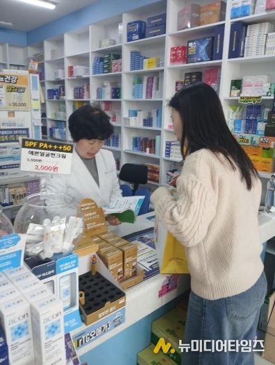 남구 치매안심약국 약사가 치매안심센터 직원의 설명을 듣고 있는 모습