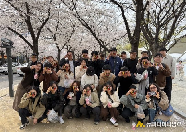 청년들이 ‘지역문화 체험 활동’에 참가해 수성못에서 벚꽃을 감상하고 필름 카메라로 풍경을 찍은 뒤 기념 촬영을 하고 있다.
