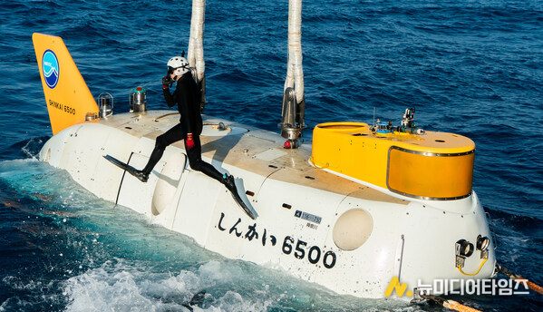 Divers jump back into the water after connecting JAMSTEC